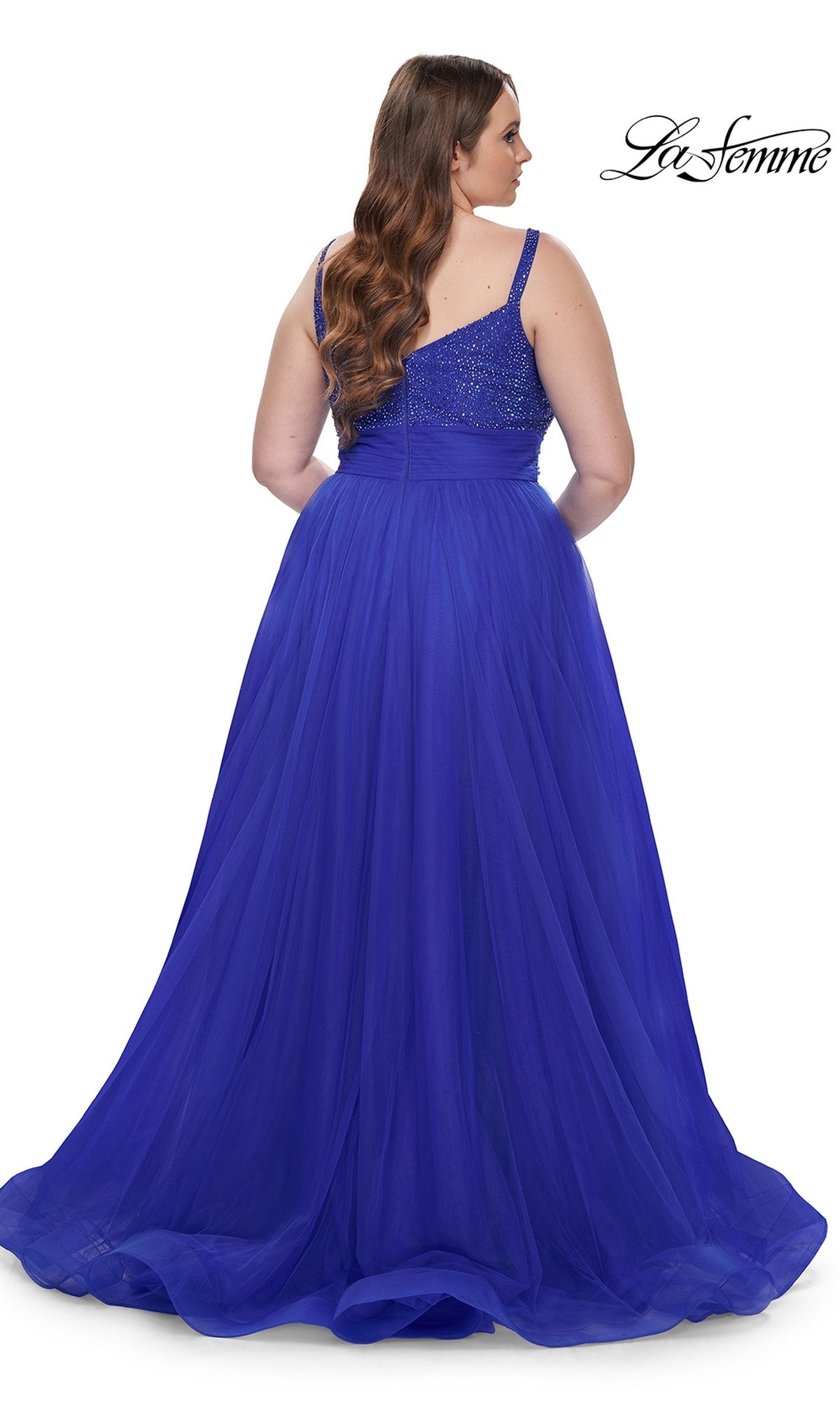 A woman is seen from behind in the La Femme Long Prom Dress 31251, a floor-length, sleeveless royal blue gown with a fitted beaded bodice, set against a white background.
